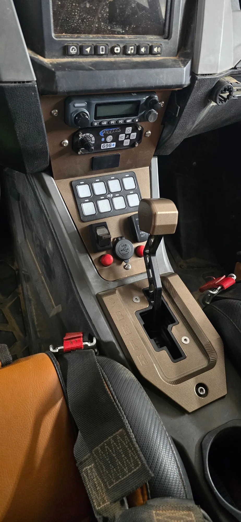 Bronze powder-coated shifter plate, knob and switch panel in a UTV dash