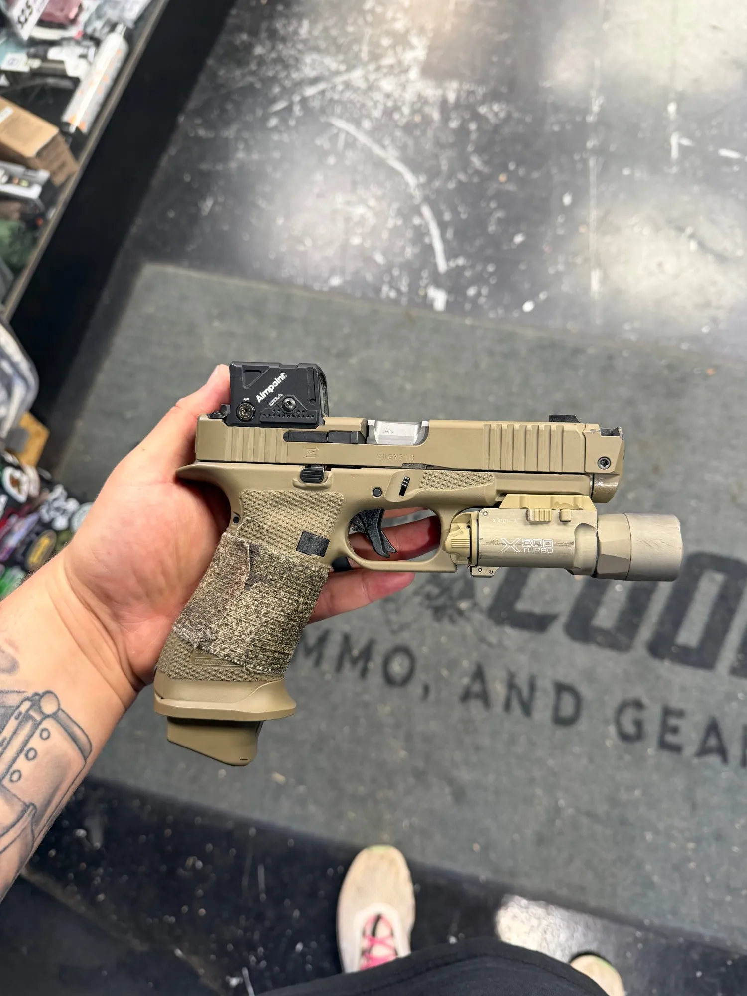 Glock pistol in flat dark earth Cerakote with a weapon light and red dot