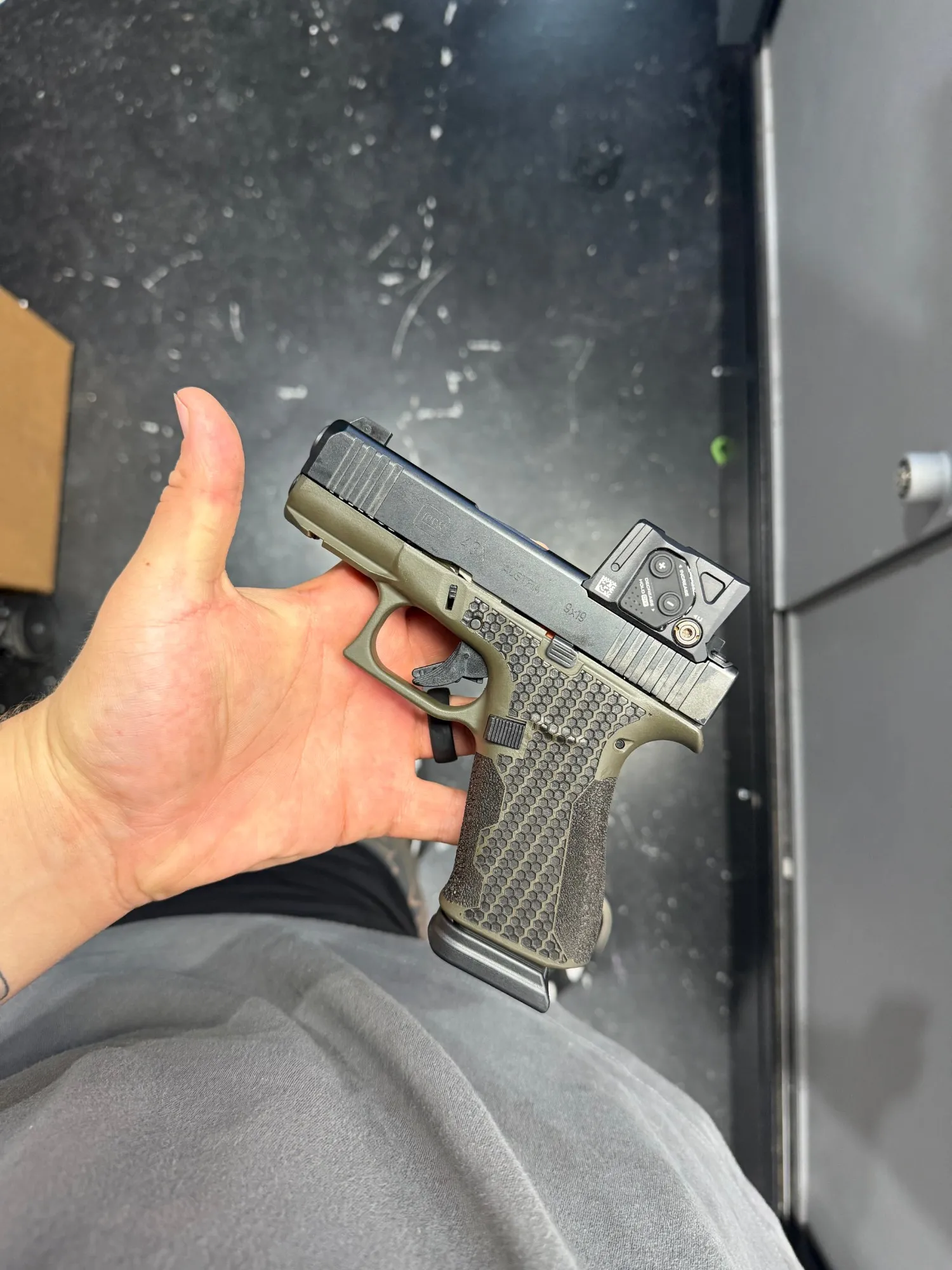 Glock 43X with an OD green Cerakote frame and hex stippling
