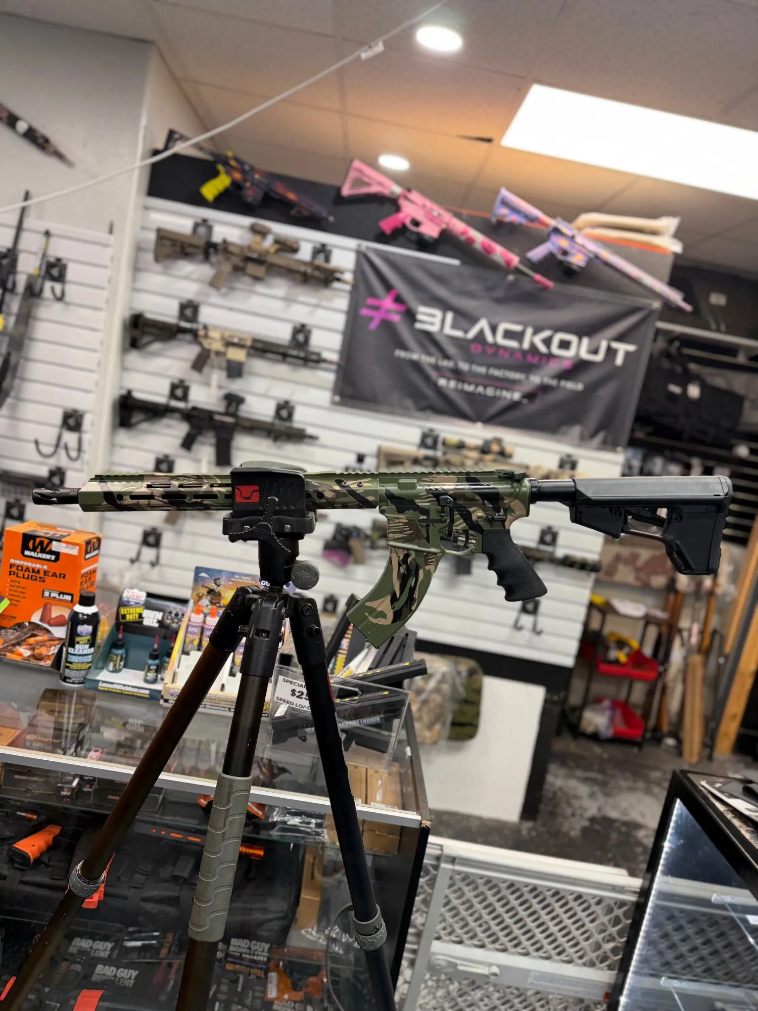 AR-style rifle in green, tan and black tiger stripe Cerakote on a tripod